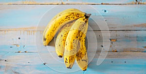 Yellow bananas on a blue wooden table background - concept of potassium and healthy lifestyle with seasonal fruit - vitamins and