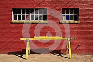 Yellow barricade with red brick wall