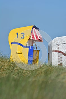 Yellow beach chair on green grass under blue sky on the North Sea coast in Cuxhaven town, Germany