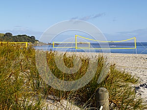 Yellow beach volleyball nets erected for use with no players yet on Mount Maunganui Main beach