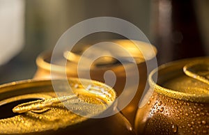 Yellow beer cans closeup in cold water droplets