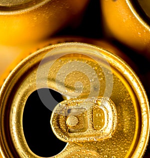 Yellow beer cans closeup in cold water droplets