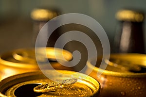 Yellow beer cans closeup in cold water droplets