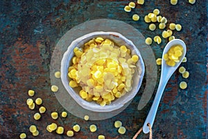 Yellow beeswax pellets in ceramic plate.