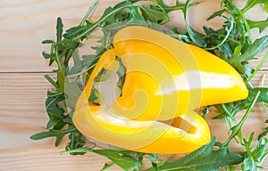 Yellow bell Pepper on rocket salad leafs background shallow dept