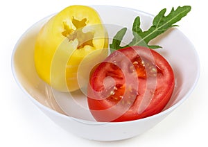 Yellow bell pepper and tomato cut across in bowl closeup