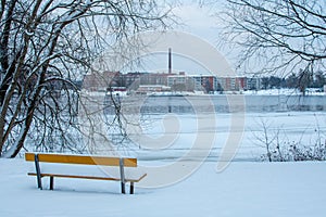 Yellow bench in a park near the lake overlooking the city in Tampere, Finland