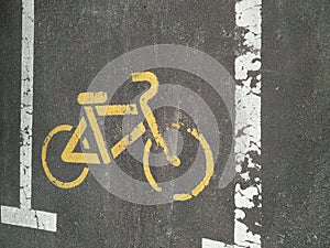 Yellow bicycle parking sign on asphalt. Road signs