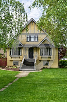 Yellow big old family house with spacios front yard.