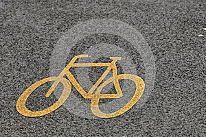Yellow bike symbol on the tarmac of a cycleway