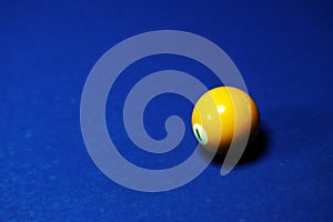 Yellow billiard ball number 1 on a blue billiard table.