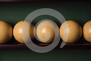 Yellow billiard balls and cue ball for billiards on the shelf,close up