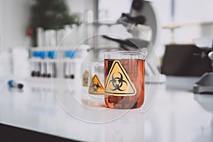 Yellow Biohazzard sign on Chemical Glassware in Lab