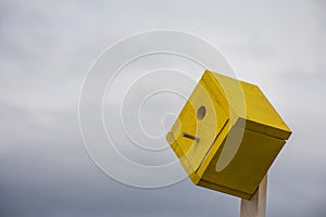 Yellow Birdhouse With Cloudy Sky Background