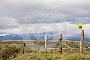 Yellow Birdhouse On A Fence In Colorado With Black Mountain In Background