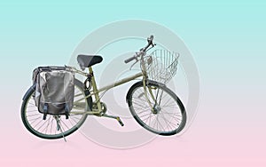 Yellow and black body of bicycle with old and silver front basket, black handles and seat which is two tone color, on green and