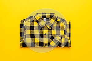 Yellow and black checkered shirt on the yellow background. centre composition