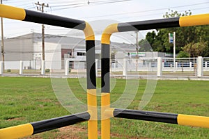 Yellow and black iron fence around small groundwater pump