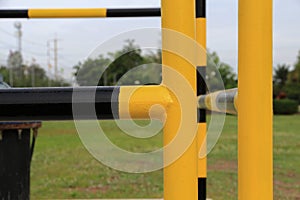 Yellow and black iron fence around small groundwater pump