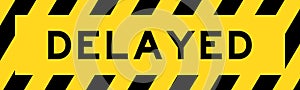 Yellow and black with line striped label banner with word delayed