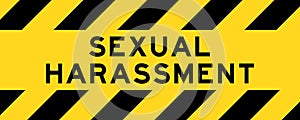 Yellow and black with line striped label banner with word sexual harassment
