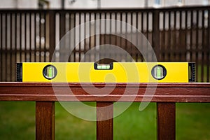 Yellow and Black Spirit Level on a wooden hand rail