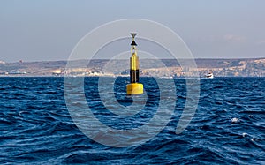 Yellow and black steel navigational floating buoy