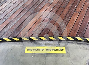 Yellow and black warning sign on step stating