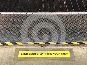 Yellow and black warning sign on step stating