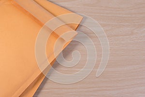 Yellow blank envelope with transparent bubble wrap or packaging shockproof on wooden table.
