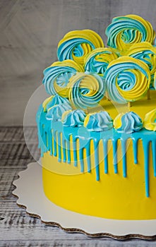 Yellow and blue cream cheese color drip cake with merengues