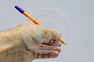 Yellow with a blue fountain pen in hand close-up on a light background.