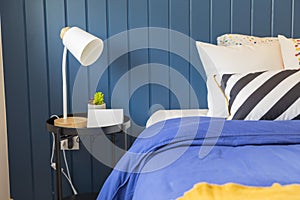 Yellow and blue graphic print pillow setting in teen bedroom.