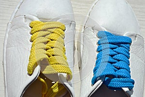 Yellow and blue laces on white shoes