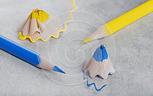 yellow and blue sharp pencil and blue and yellow pencil shavings.