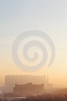 Yellow and blue sunrise sky over urban houses