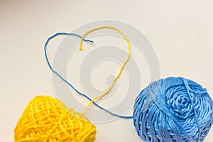 Yellow and blue threads in heart shape. Ukrainian national colors. Patriotic ukrainian background. Love Ukraine concept.