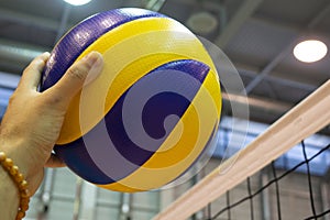 Yellow-blue volleyball on the floor in the gym