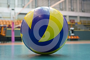 Yellow-blue volleyball on the floor in the gym