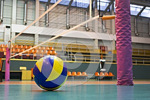 Yellow-blue volleyball on the floor in the gym