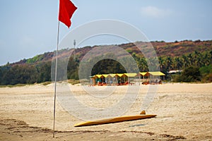 The yellow board of the rescuer for surfing lies on the sand used by the lifeguard working on the Arambol beach
