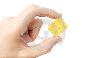 Yellow bouillon cube in hand. Isolate on a white background.