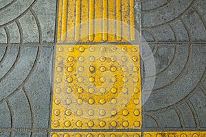 Yellow Braille Blocks on the Sidewalk, Providing a Pathway for Visually Impaired Individuals