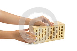 Yellow brick brick block on a white background in the hands of