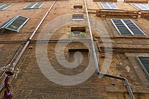 Yellow brick wall of the ancient building with downspouts