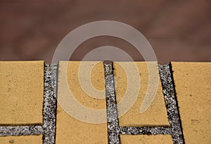 Yellow brick wall closeup with red brown soft blurred background