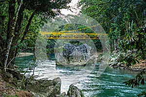 Yellow bridge over a lovely river in Semuc Champey, Guatemala