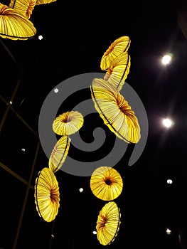 Yellow bright lampshades hanging from the ceiling