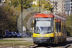 Yellow bright modern close-up trams in Sunny weather in the autumn European city of Warsaw, Poland. Comfortable public transport