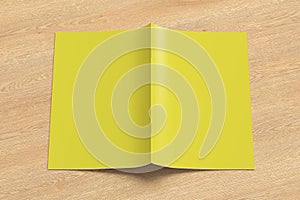 Yellow brochure or booklet cover mock up on wooden background. Brochure is open and upside down. Isolated with clipping path aroun